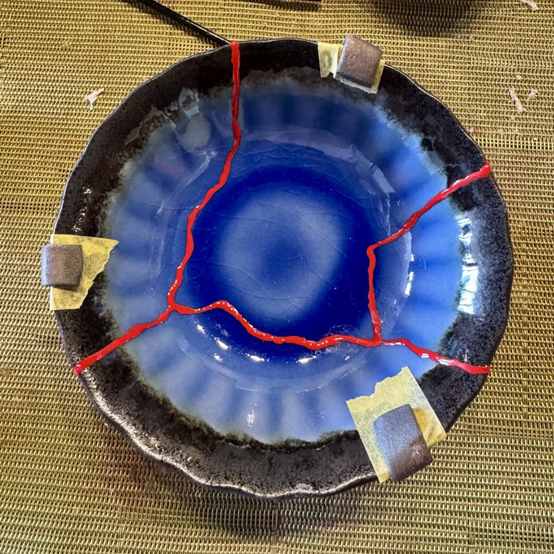 A blue ceramic bowl marked with red lines